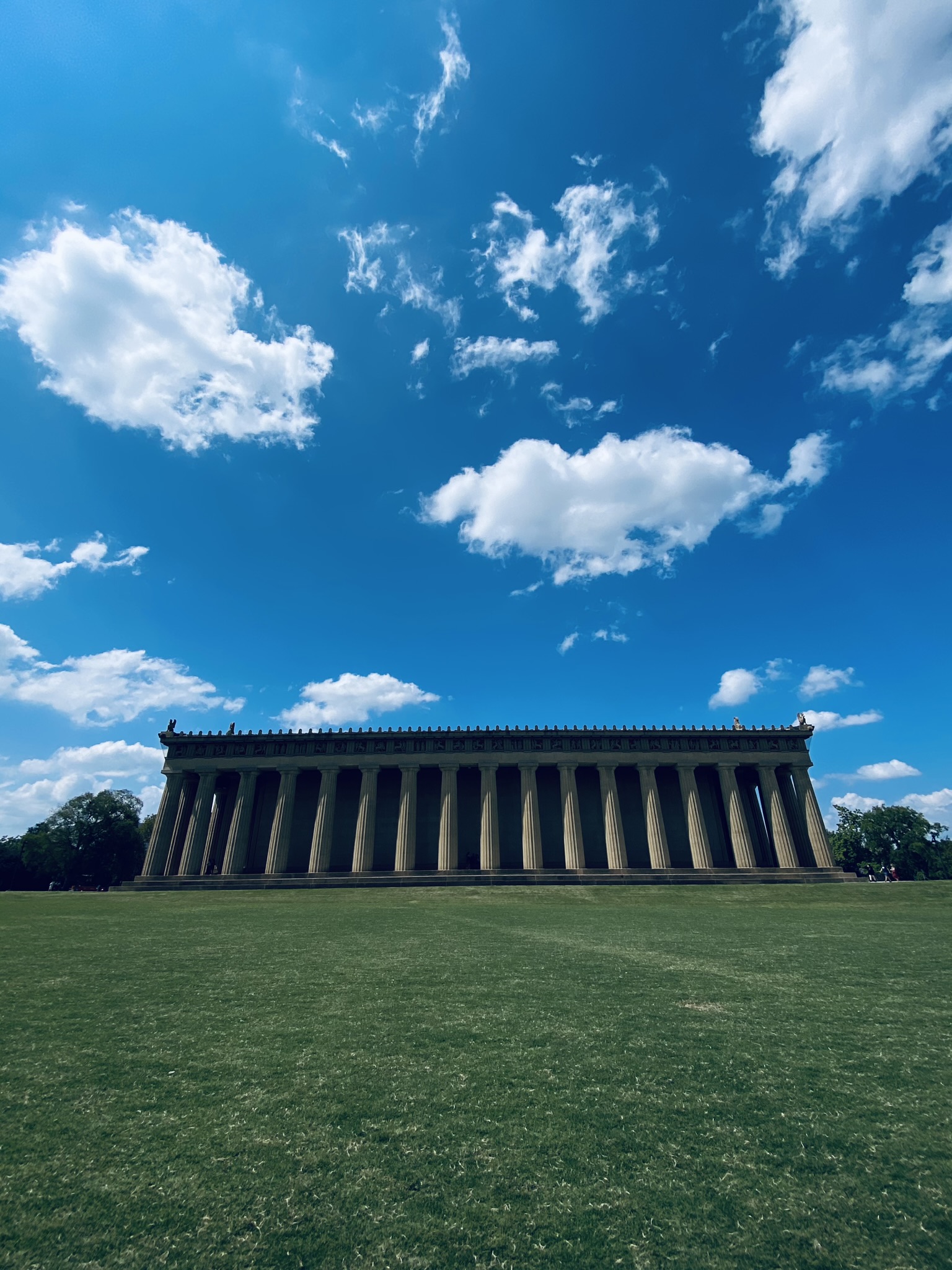 A large Greek style building, exact replica of the columned Parthenon.